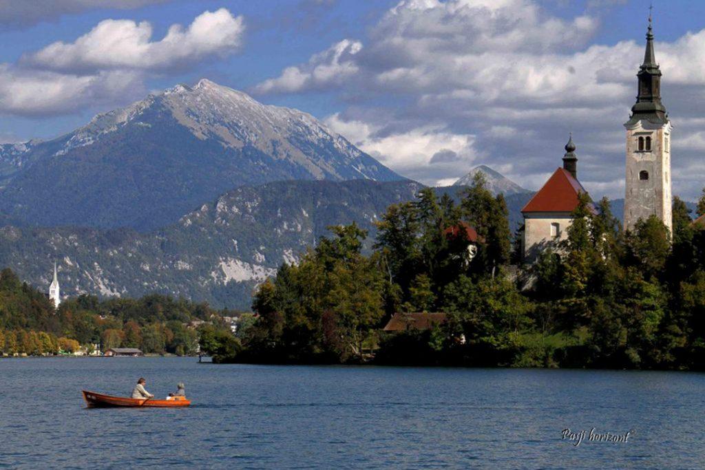 Pogled iz sprehajalne poti okoli Bleda na otok in cerkev Marijinega vnebovzetja