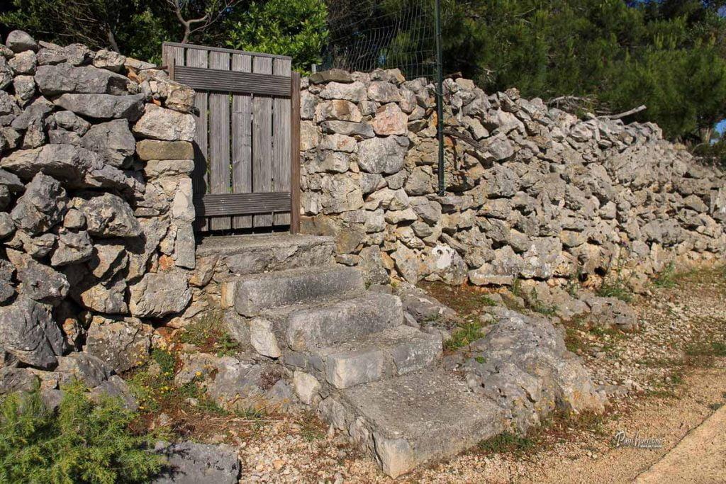 Lesena vratca v kamniti ograji ob poti, Cres